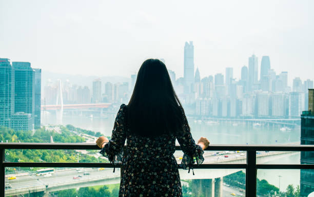 istock Young woman standing looking city skyline 1062134144