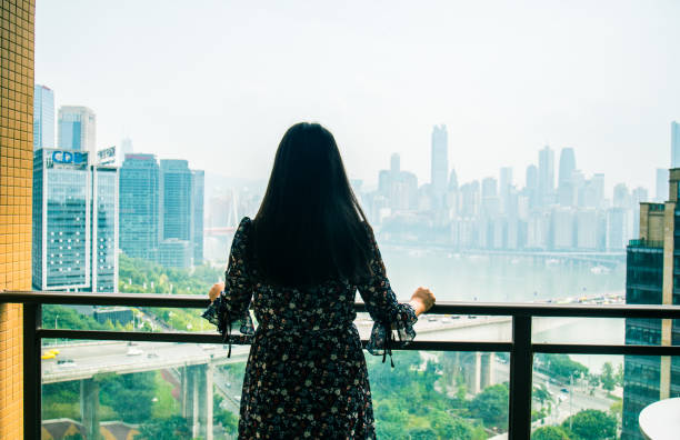 istock Young woman standing looking city skyline 1062134174