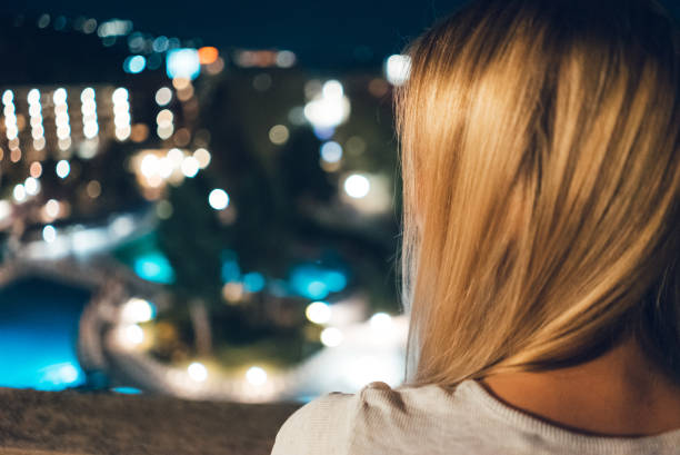 istock Young woman on hotel balcony at night 1062136850
