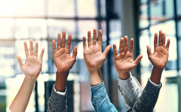 We'd like to volunteer Cropped shot of a group of unrecognizable businesspeople raising their hands volunteer photos stock pictures, royalty-free photos & images