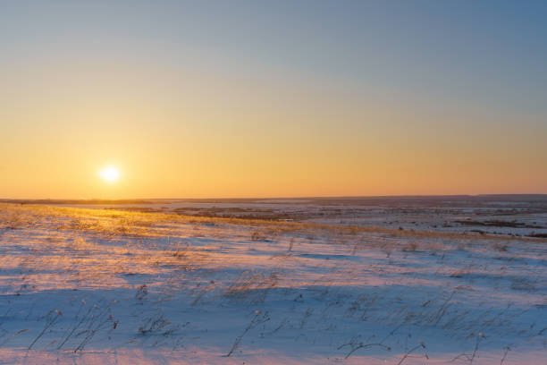 istock Winter landscape with snow covered plain, blue sky and orange su 1062141738