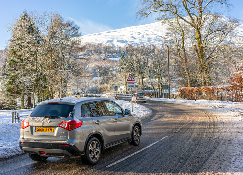 Lochearnhead, Scotland, UK - Cars on a corner during January, following heavy snow in the Trossachs area of Scotland.
