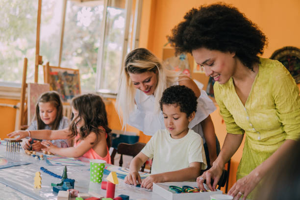 istock Happy art teachers looking at students 1062147454