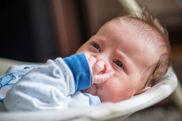 istock Sleeping baby in swing automatic electrical chair and sucking left thumb 1062148918