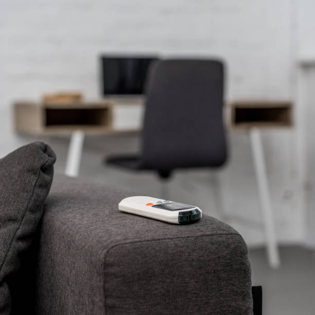 istock close-up shot of air conditioner remote control lying on sofa with workplace on background 1062149566