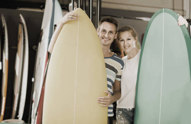 istock couple is demonstraiting surfboard in nautical shop. 1062158358