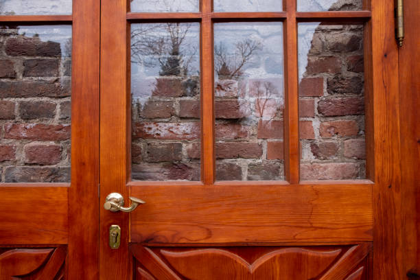 istock Red brick wall behind glass door or window. 1062159296