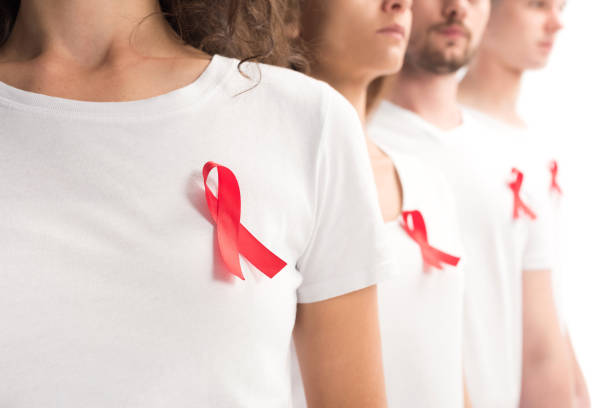 przycięty wizerunek ludzi stojących z czerwonymi wstążkami na białych koszulach odizolowanych na białym, koncepcja światowego dnia pomocy - world aids day zdjęcia i obrazy z banku zdjęć
