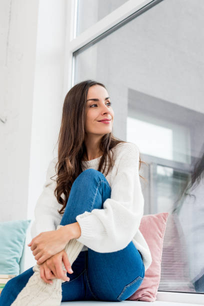 istock bottom view of smiling thoughtful young woman looking through window 1062161906