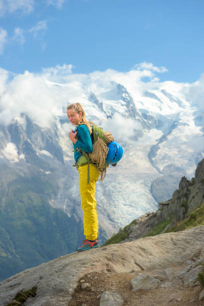 A group of 6 tourist climbers are ascending a snow-covered ridge in the Mont Blanc mountain range in Chamonix France.