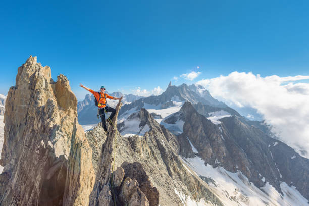 alpinista siedzący na ostrym szczycie skalnym - mountain climbing rock climbing motivation awe zdjęcia i obrazy z banku zdjęć