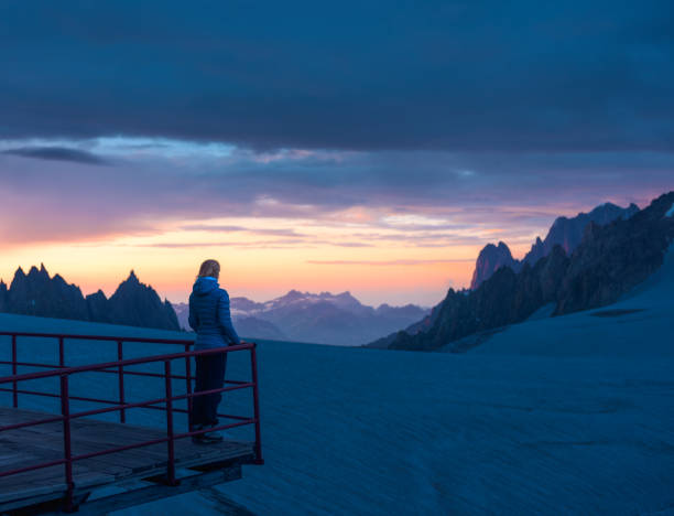 Woman looking at the splendid sunset in the mountains