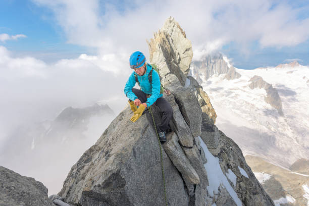 Mountaineer on the summit of Dent Du Geant Woman mountaineer standing on the summit of Dent du Geant in the Alps dent du geant stock pictures, royalty-free photos & images