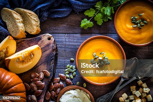 istock Pumpkin soup with ingredients on rustic wooden table 1062175262