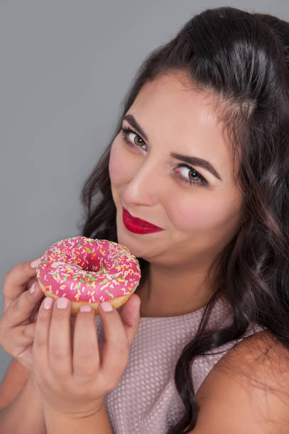 istock Beautiful happy plus size woman with donut 1062180356