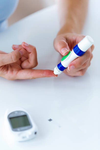 istock Young woman pricking herself to get a blood sample and perform a glucose test. 1062188618