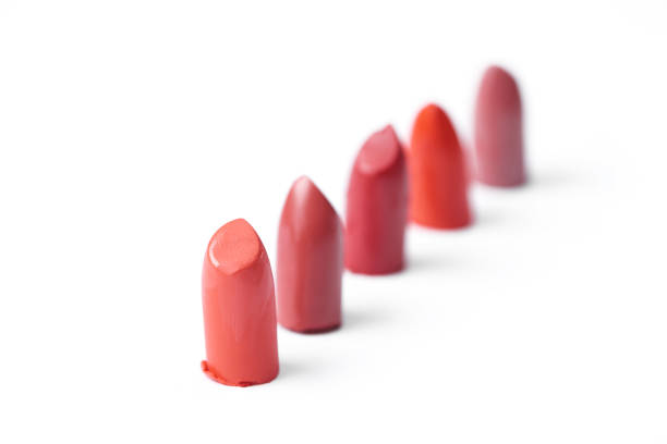 close up view of cut lipsticks on different colors on white backdrop