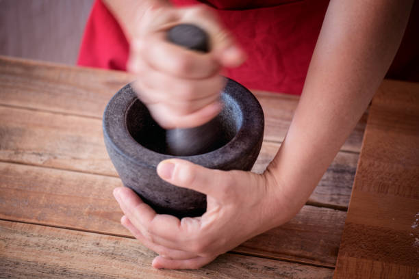 Ginger bread cookies making, crushing spices using mortar and pestle. close-up. Blurred motion, long exposure