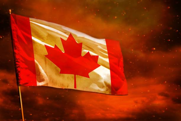 istock Fluttering Canada flag on crimson red sky with smoke pillars background. Troubles concept. 1062197600