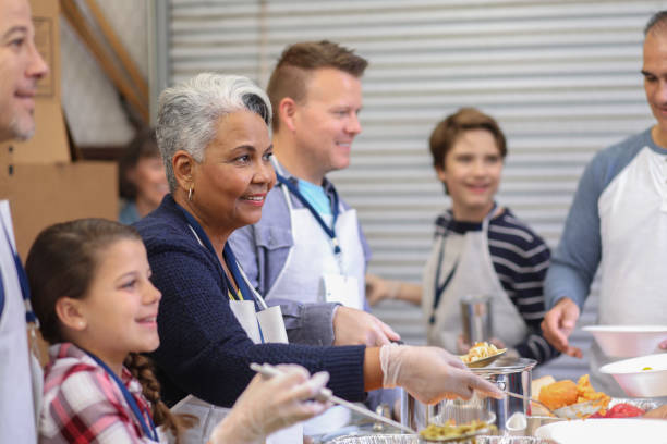 istock Multi-ethnic group of volunteers serves food at soup kitchen. 1062199846