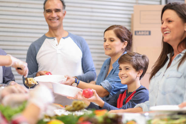 istock Multi-ethnic group of volunteers serves food at soup kitchen. 1062201050