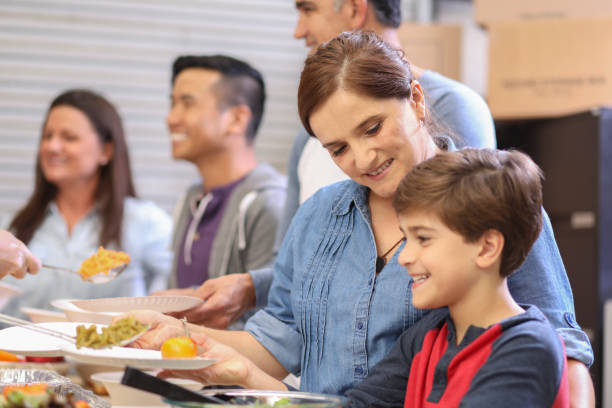 istock Multi-ethnic group of volunteers serves food at soup kitchen. 1062201088