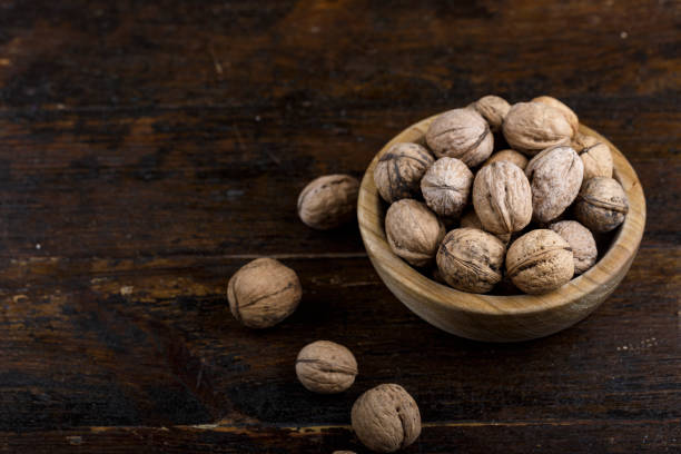istock inshell whole walnuts on dark wooden background. 1062204378