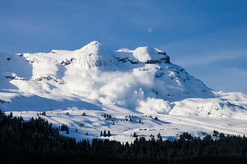 Enorme real avalancha en los Alpes franceses con el cielo azul y Luna photo