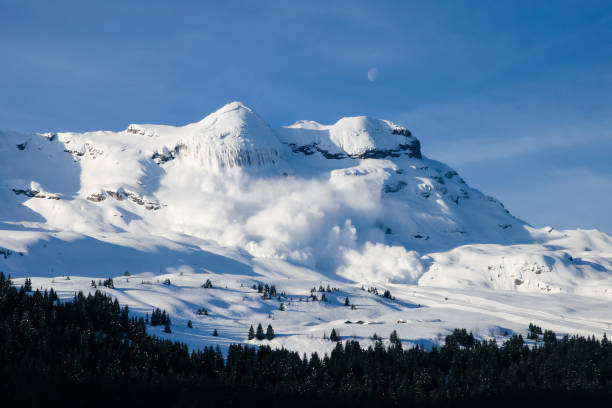 Huge real avalanche in the French Alps with the moon and blue sky Big snow avalanche in the french moutains avalanche stock pictures, royalty-free photos & images