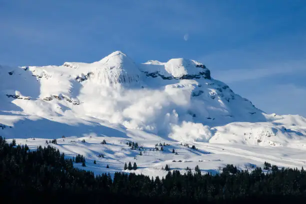 Photo of Huge real avalanche in the French Alps with the moon and blue sky