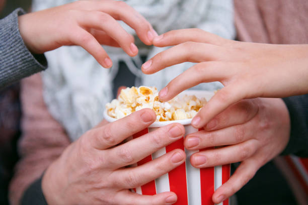 istock close-up of popcorn and hands 1062220612