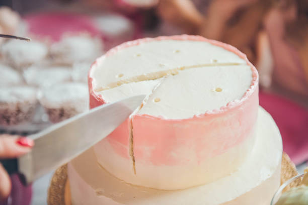 istock Woman's hands cut the cake with pink cream. 1062222658
