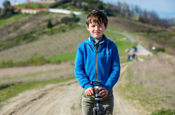 Child with photo tripod on his shoulder