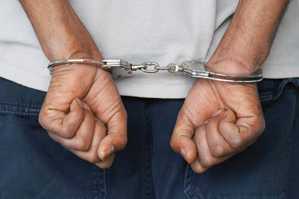 istock Criminal hands locked in handcuffs. Close-up view 1062247314