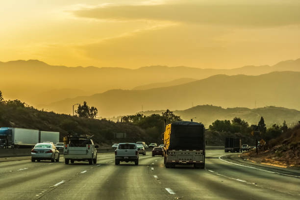 Interstate traffic near Anaheim, Los Angeles, on a nice evening of summer before sunset with San Gabriel mountain range in the background, California, USA.
