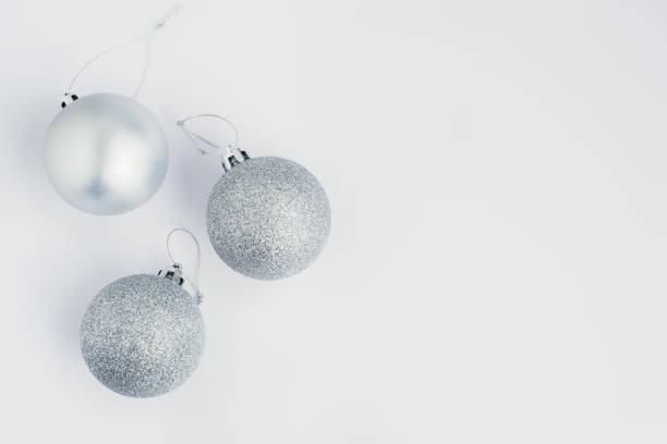 silver christmas decorations balls over white background with copy space, flat lay stock photo