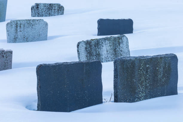 istock Granite textured tombstones emerging from winter snow in graveyard 1062257366