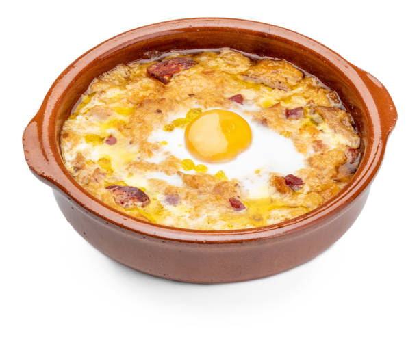 istock Garlic and bread soup (Spanish, from Spain) in clay pot. View from above. Isolated on white background. 1062259576