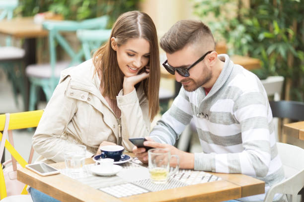 istock Young couple texting in cafe outdoors 1062259966