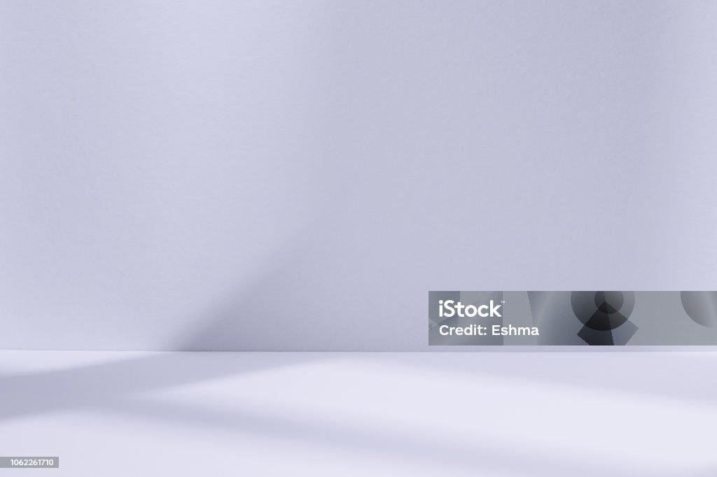 Light blue studio space with window shadow Empty light blue studio space with deep windows shadow. Sparse template and background Backgrounds Stock Photo