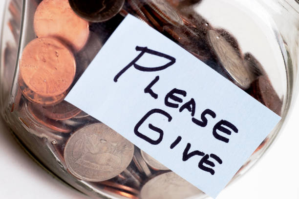 istock PLEASE GIVE Label on Jar of Coins Isolated on White 1062272038