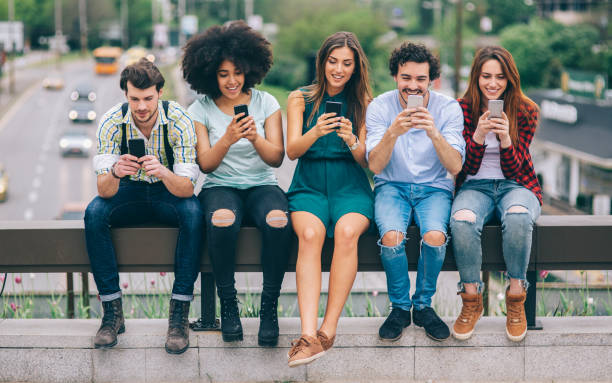 istock Young people sitting outdoors and surfing the net 1062274302
