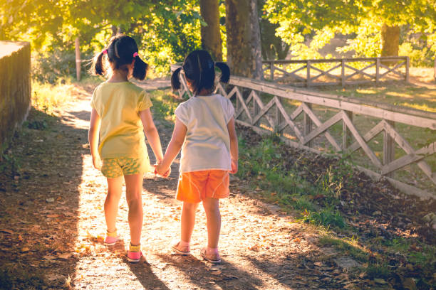 istock Anonymous girls holding hands in park 1062280956