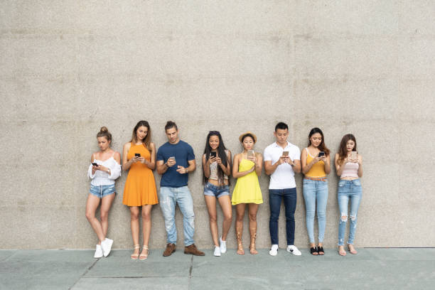 istock Young adults leaning back on wall and social networking 1062314260