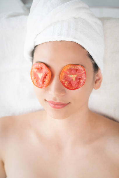 istock Woman getting eye nature treatment by tomato. 1062332632