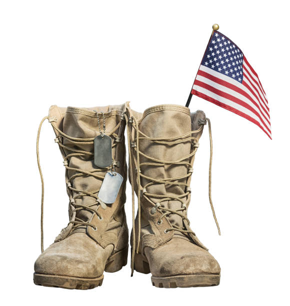 Old military combat boots with the American flag and dog tags Old military combat boots with the American flag and dog tags, isolated on white background. Memorial Day or Veterans day concept. boot photos stock pictures, royalty-free photos & images