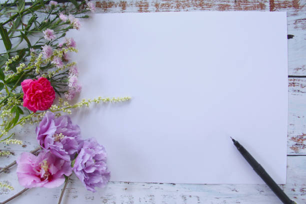 istock Rose flower with empty paper  on wooden background. 1062359452