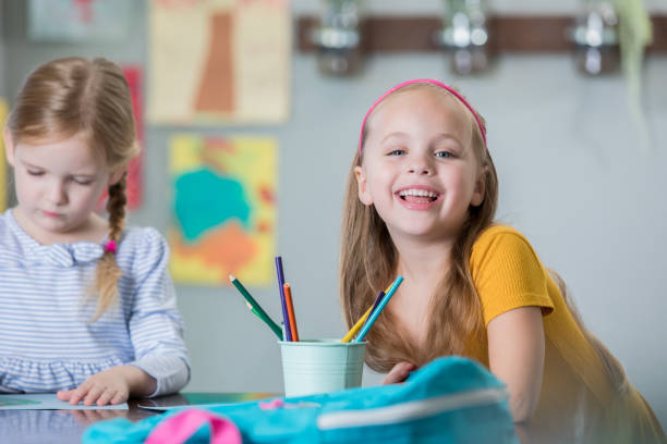 istock Kindergarten student smiling at desk with classmate 1062370528