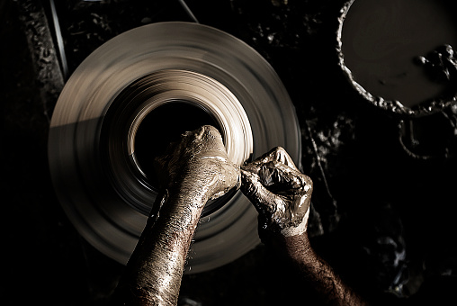 Hands of a potter, creating an earthen jar