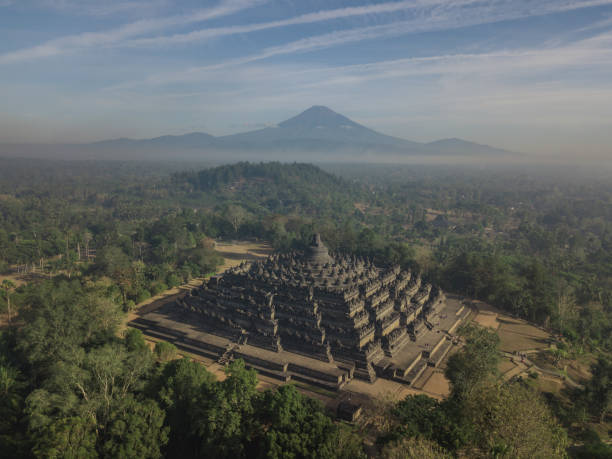 un matin brumeux au temple borobudur avec les volcans en arrière-plan - borobudur ruins photos et images de collection